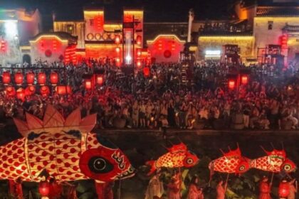Corteo di lanterne rosse a forma di pesce tra le case tradizionali di un villaggio di Huangshan