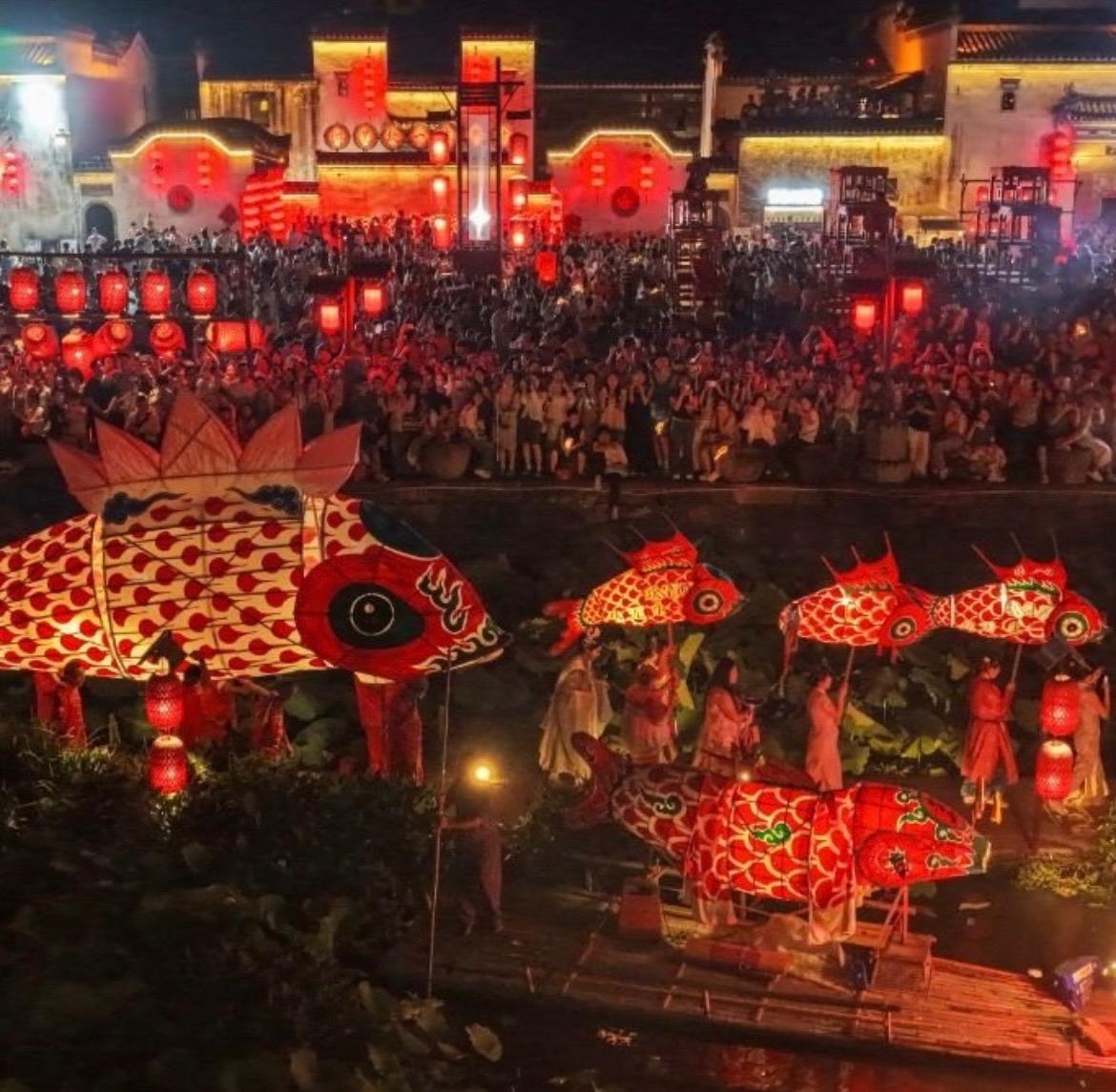 Corteo di lanterne rosse a forma di pesce tra le case tradizionali di un villaggio di Huangshan